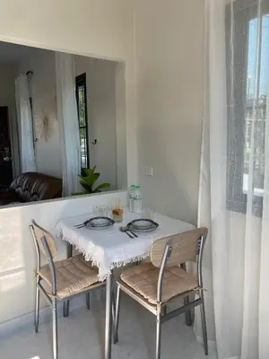 a dining room table with two chairs and a white table and chairsearcher at Detached house Rawai beach in Ban Saiyuan (1)