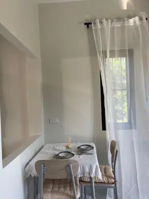 a dining room table with two chairs and a window at Detached house Rawai beach in Ban Saiyuan (1)