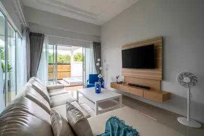 a living room with a couch and a flat screen tv at Laguna Beach Villa Phuket 207byน้องมังคุด in Ban Pak Lak