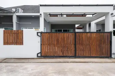 a house with a wooden gate in front of it at Laguna Beach Villa Phuket 207byน้องมังคุด in Ban Pak Lak