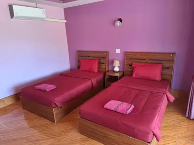 two beds in a room with purple walls at ทุ่งนา รีสอร์ท Rice Field Resort in Ban Khiam Ngam
