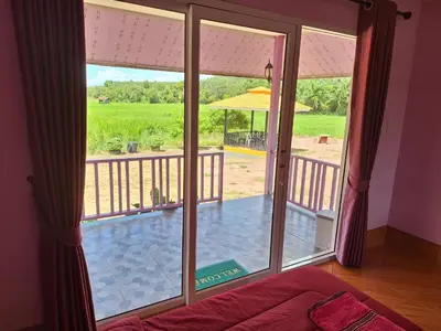a room with a large window with a view of a patio at ทุ่งนา รีสอร์ท Rice Field Resort in Ban Khiam Ngam