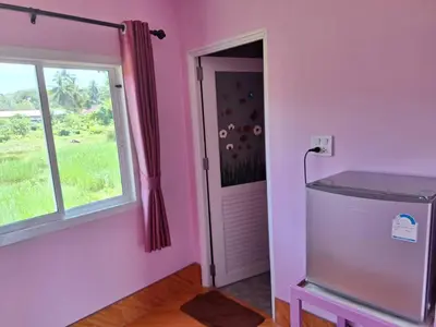a pink room with a door and a window at ทุ่งนา รีสอร์ท Rice Field Resort in Ban Khiam Ngam
