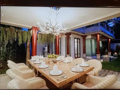 a dining room with a table and chairs and a chandelier at Villa in the Park, Surin Beach, Phuket in Surin Beach