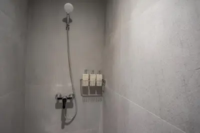 a shower in a bathroom with towels on a wall at Villa in the Park, Surin Beach, Phuket in Surin Beach
