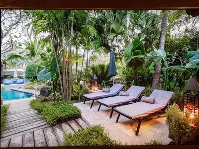 a patio with two lounge chairs and a pool at Villa in the Park, Surin Beach, Phuket in Surin Beach