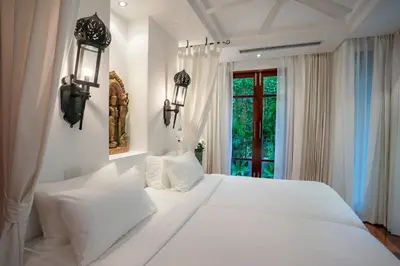 a white bedroom with a large white bed and a window at Villa in the Park, Surin Beach, Phuket in Surin Beach