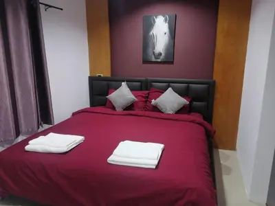 a bedroom with a red bed with white towels on it at Patong Beach Dream House in Patong Beach