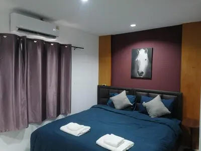 a bedroom with a blue bed with two towels on it at Patong Beach Dream House in Patong Beach