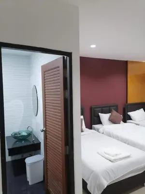 a bedroom with two beds and a mirror in it at Patong Beach Dream House in Patong Beach