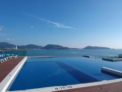 a swimming pool with a view of the water at Spacious apartment with ocean view & jacuzzi in Patong Beach