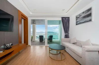 a living room with a couch and a table at Spacious apartment with ocean view & jacuzzi in Patong Beach