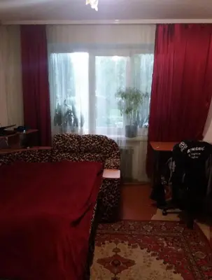 a bedroom with a bed and a window with red curtains at Dimadom in Patong Beach