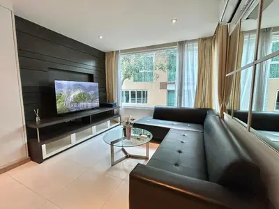 a living room with a couch and a tv at 1 bedroom walk to Kalim in Patong Beach