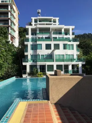 a building with a swimming pool in front of a building at 1 bedroom walk to Kalim in Patong Beach