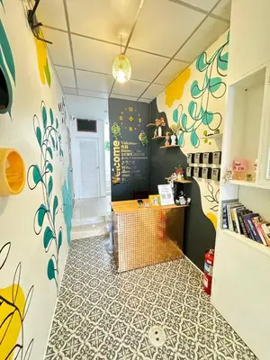 a room with a desk and a wall with flowers on it at Pupa Women Hostel in Patong Beach