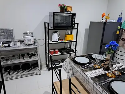 a kitchen with a table and a stove and a tv at 2 bedroom house in Thalang in Ban Pak Lak