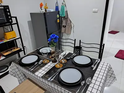 a table with plates and utensils on top of it at 2 bedroom house in Thalang in Ban Pak Lak