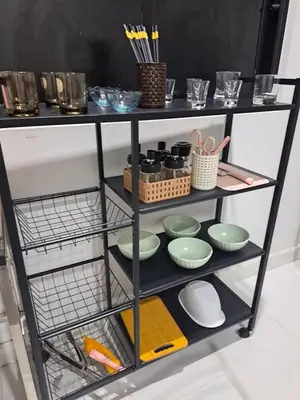 a shelf with bowls and utensils on it at 2 bedroom house in Thalang in Ban Pak Lak
