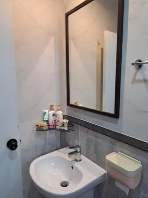 a bathroom with a sink and a mirror and a toilet at 2 bedroom house in Thalang in Ban Pak Lak