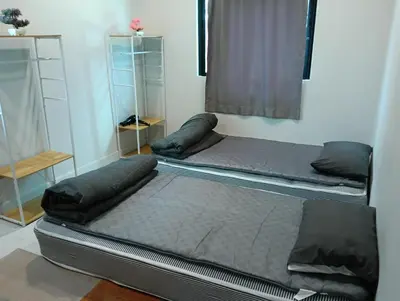two beds in a room with a window at 2 bedroom house in Thalang in Ban Pak Lak