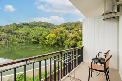 a balcony with two chairs and a view of a river at The Pinnacle Katanoi in Kata Beach