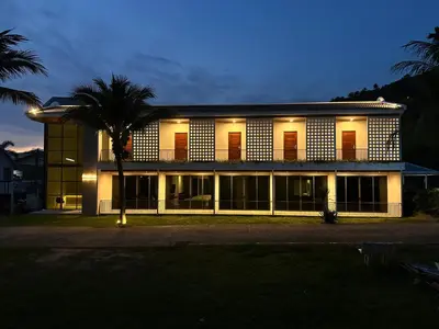 a building with a palm tree in front of it at The Pinnacle Katanoi in Kata Beach