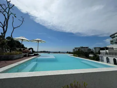 a swimming pool with a blue sky in the background at Palmetto пляж Карон квартира для отпуска in Karon Beach