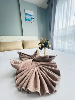 a vase of flowers sitting on top of a bed at Pool View Apartments-Kathu,Phuket in Kathu