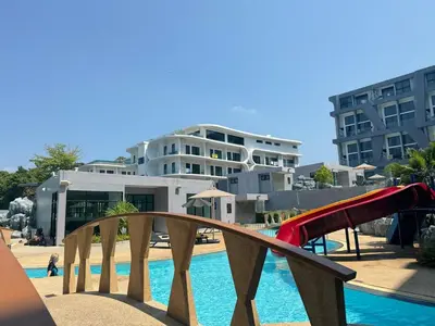 a playground in front of a pool with a slide at Utopia Loft Condo in Nai Harn Beach