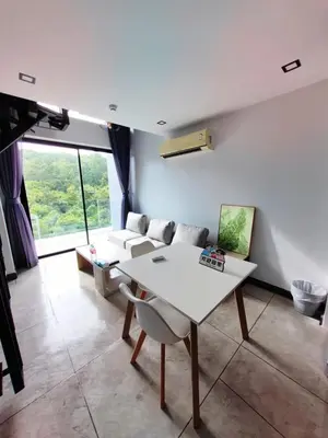 a living room with a white table and chairs at Utopia Loft Condo in Nai Harn Beach