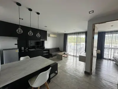 a kitchen and living room with a table and chairs at 1-bedroom apartment Naiharn Beach B403 in Rawai Beach