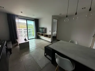 a living room with a dining table and a bedroom at 1-bedroom apartment Naiharn Beach B403 in Rawai Beach