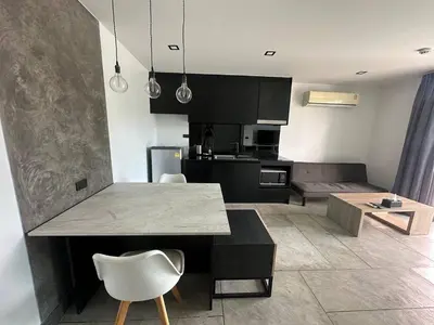 a kitchen and living room with a table and chairs at 1-bedroom apartment Naiharn Beach B403 in Rawai Beach