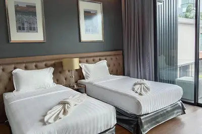 a hotel room with two beds and a window at villa kamala regent 2 bedrooms in Kamala Beach