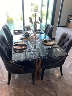a dining room table with chairs and a table with glasses at villa kamala regent 2 bedrooms in Kamala Beach