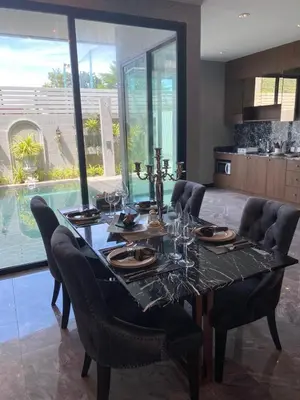 a dining room with a table and chairs and a pool at villa kamala regent 2 bedrooms in Kamala Beach