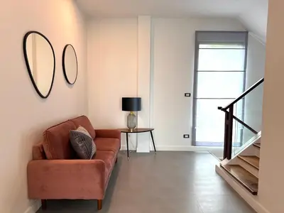 a living room with a couch and a mirror on the wall at Luxury 3BR Triplex Jacuzzi & Sea View PANDORA RESIDENCES in Nai Harn Beach