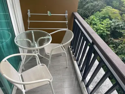 two chairs and a table on a balcony at Two Room MiamiStyle Perfect for Digital Nomads in Ban Saiyuan (1)