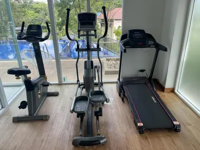 a gym with three exercise bikes in a room at Two Room MiamiStyle Perfect for Digital Nomads in Ban Saiyuan (1)