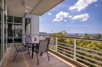 a balcony with a table and chairs and a view at Exquisite Sea View Luxury Apartment Veloche group in Karon Beach
