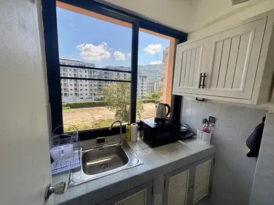 a kitchen with a sink and a window with a view at Kimchi Apartment in Patong Beach