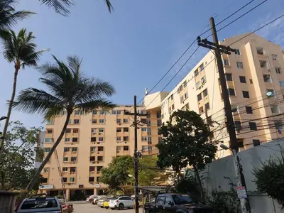 a large building with palm trees in front of it at Kimchi Apartment in Patong Beach