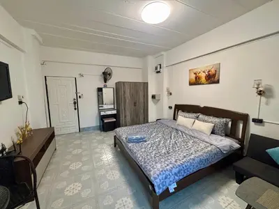 a bedroom with a bed and a television in it at Kimchi Apartment in Patong Beach