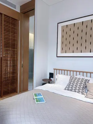 a bedroom with a bed with a book on it at Tree O'clock Pool Villa - Phuket in Thalang