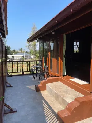 a patio with a table and chairs and a fence at Niyang Siam House in Nai Yang Beach