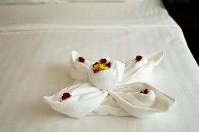 a group of three white towels on a bed at Yenna Apartment in Kamala Beach
