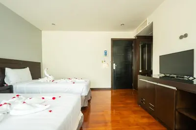 a hotel room with two beds and a flat screen tv at Yenna Apartment in Kamala Beach