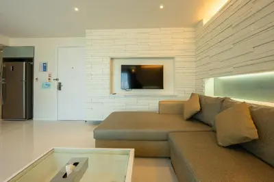 a living room with a couch and a tv at Yenna Apartment in Kamala Beach