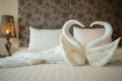 two white swans making a heart on a bed at Yenna Apartment in Kamala Beach